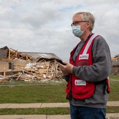 Red Cross volunteer surveying the damage caused by a disaster